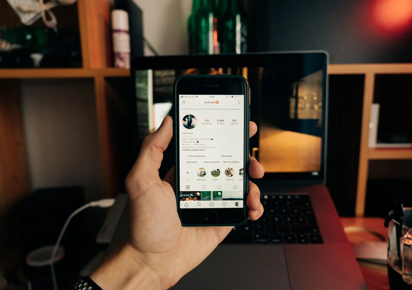 Hand holding a smartphone with a social feed